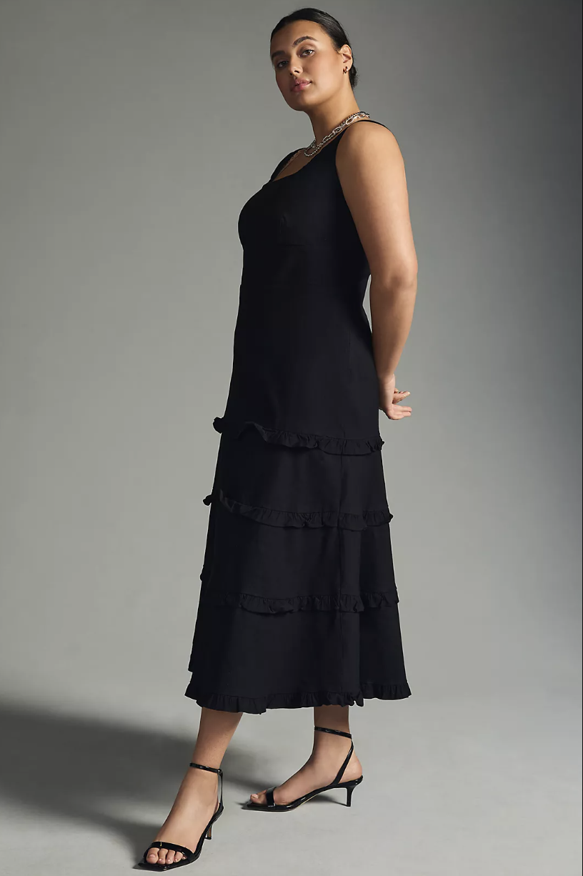 plus size model wearing black heeled sandals and black The Blythe Square-Neck Tiered Dress (photo via Anthropologie)