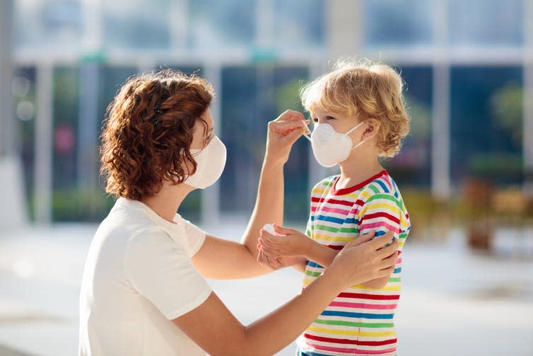 A mother and her child wearing masks