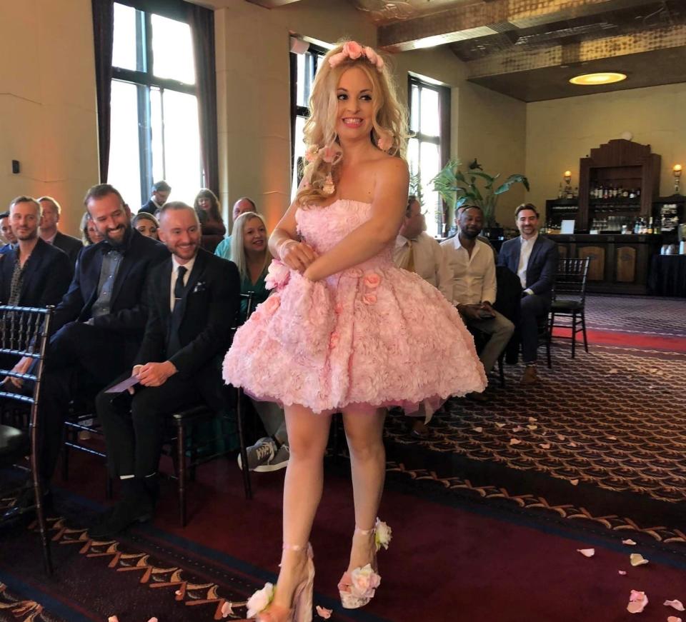 Flower girl Helena Levin aka California Barbie Princess tosses rose petals down the aisle at her friends' wedding at The City Club of San Francisco on July 16, 2022.