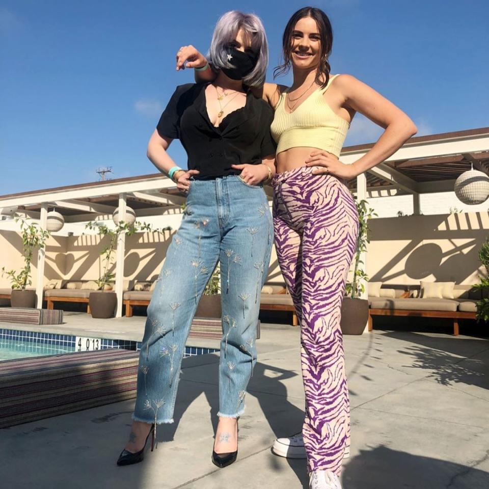 Kelly Osbourne in a black mask and jeans with her friend