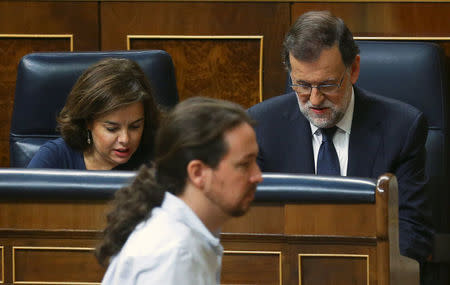 Leader of Podemos (We Can) party Pablo Iglesias (C) walks past Spain's acting Prime Minister Mariano Rajoy (R) and acting Deputy Prime Minister Soraya Saenz de Santamaria during the investiture debate at Parliament in Madrid, Spain, October 27, 2016. REUTERS/Andrea Comas