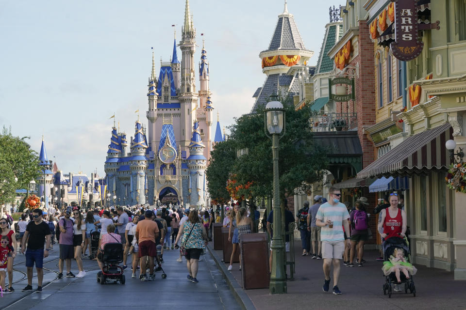 FILE - Guests stroll along Main Street at the Magic Kingdom theme park at Walt Disney World on Aug. 30, 2021, in Lake Buena Vista, Fla. A theme-park comeback continued to boost Disney's results in the most recent quarter. The company also added more subscribers to its Disney+ streaming service than analysts expected. (AP Photo/John Raoux, File)