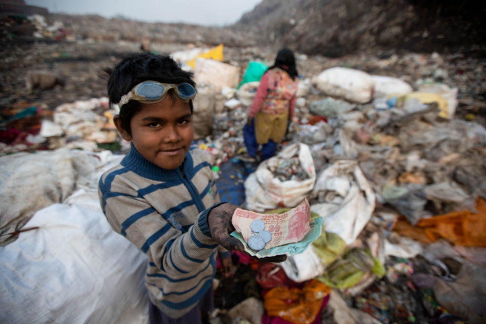 A 10-year-old ragpicker shows the money he earned after selling recyclable items he collected at the Bhalswa garbage dump in New Delhi.<span class="copyright">Vijay Pandey/Picture Alliance via Getty Images</span>