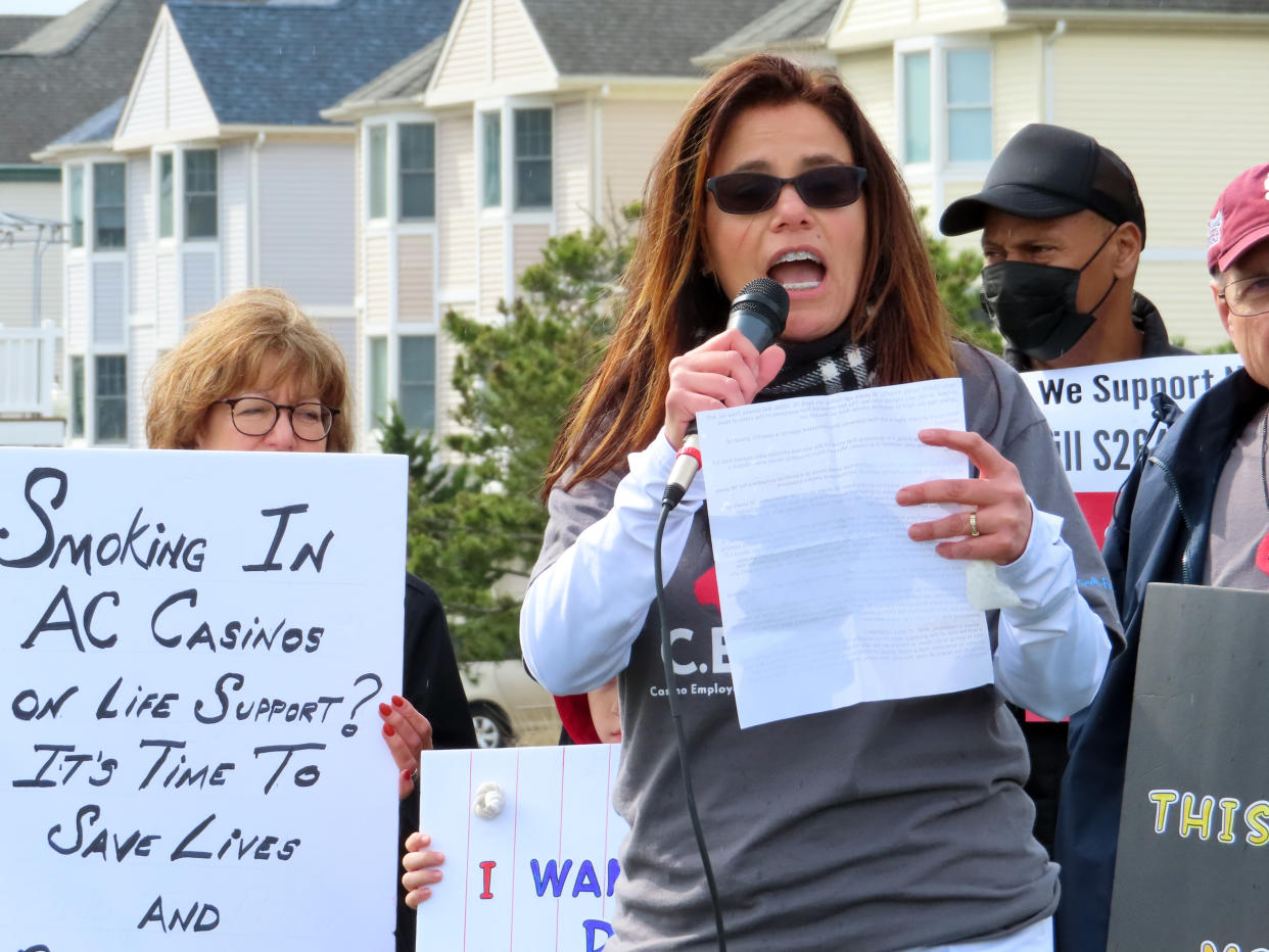 FILE - Nicole Vitola, a dealer at the Borgata casino, speaks at a rally in Atlantic City, N.J., on April 12, 2022 calling on state lawmakers to ban smoking in the gambling halls. A report issued Friday, June 17, 2022, by a Las Vegas gambling research company suggested that ending smoking in casinos will not result in significant financial harm to the businesses. (AP Photo/Wayne Parry, File)