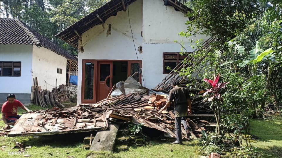 A photo shows people inspect a collapsed house following a 6.0 magnitude earthquake that hit in Blitar, East Java, Indonesia.