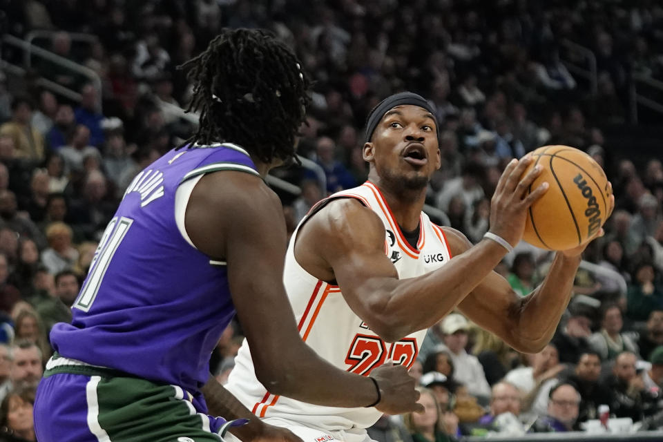 Miami Heat's Jimmy Butler, right, looks to shoot against Milwaukee Bucks' Jrue Holiday during the first half of an NBA basketball game Friday, Feb. 24, 2023, in Milwaukee. (AP Photo/Aaron Gash)