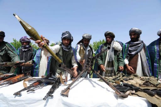 Former Taliban fighters display their weapons as they join Afghan government forces during a ceremony in Herat province on April 26. The US, Pakistan and Afghanistan have agreed to set up a group to look at how Taliban fighters who wanted to be part of the peace process could be included