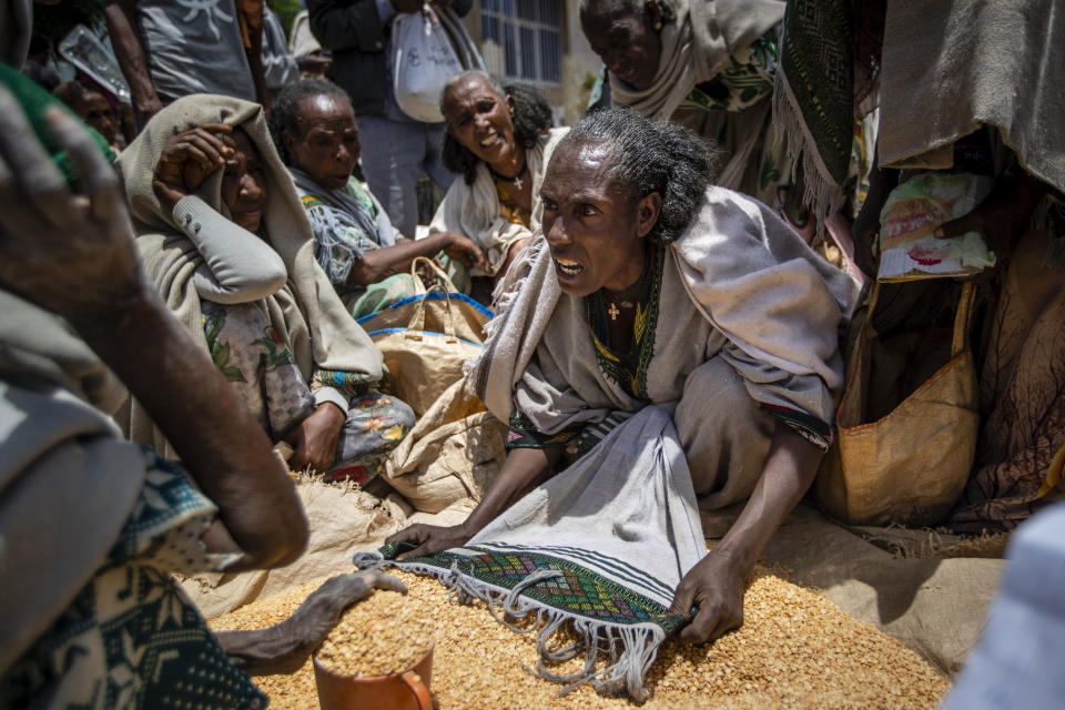 FILE - In this Saturday, May 8, 2021 file photo, an Ethiopian woman argues with others over the allocation of yellow split peas after it was distributed by the Relief Society of Tigray in the town of Agula, in the Tigray region of northern Ethiopia. In an interview with The Associated Press Tuesday, Sept 28, 2021, the United Nations humanitarian chief Martin Griffiths calls the crisis in Ethiopia a "stain on our conscience" as children and others starve to death in the Tigray region under what the U.N. calls a de facto government blockade of food, medical supplies and fuel. (AP Photo/Ben Curtis, File)