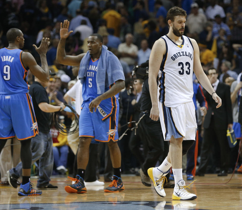 Memphis Grizzlies center Marc Gasol (33) leaves the court as Oklahoma City Thunder players Serge Ibaka (9) and Kendrick Perkins (5) celebrate after overtime in Game 4 of an opening-round NBA basketball playoff series Saturday, April 26, 2014, in Memphis, Tenn. Oklahoma City won 92-89. (AP Photo/Mark Humphrey)