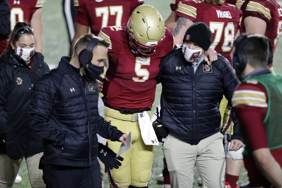 Boston College quarterback Phil Jurkovec (5) is helped off the field beside head coach Jeff Hafley, second from left, during the second half of an NCAA college football game against Louisville, Saturday, Nov. 28, 2020, in Boston. (AP Photo/Michael Dwyer)
