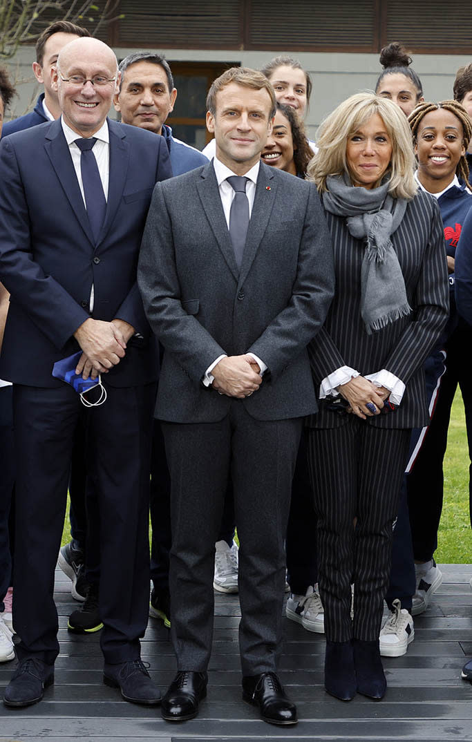 French President Emmanuel Macron, Brigitte Macron and French Rugby Federation president Bernard Laporte pose with France’s mens and women’s national rugby union teams at their training center in Marcoussis, France. - Credit: AP