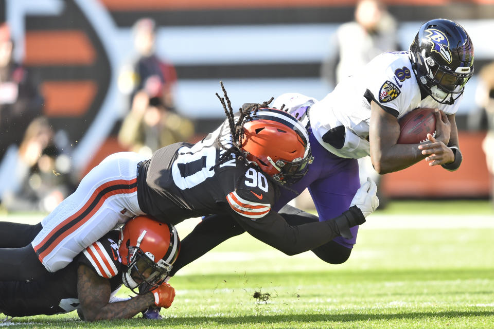 Cleveland Browns linebacker Jadeveon Clowney (90) tackles Baltimore Ravens quarterback Lamar Jackson (8) for no gain during the first half of an NFL football game, Sunday, Dec. 12, 2021, in Cleveland. (AP Photo/David Richard)