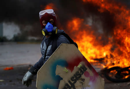 A demonstrator looks on as motorcycles belonging to riot security forces are set on fire during a rally against Venezuela's President Nicolas Maduro in Caracas, Venezuela, May 31, 2017. REUTERS/Carlos Garcia Rawlins