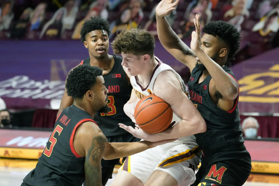 Maryland's Eric Ayala (5) and a teammate double-team Minnesota's Liam Robbins, center, in the first half of an NCAA college basketball game, Saturday, Jan. 23, 2021, in Minneapolis. (AP Photo/Jim Mone)