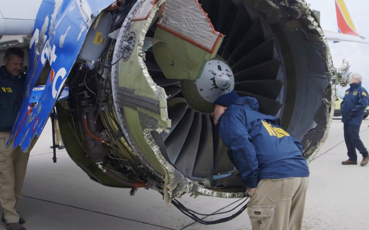 A National Transportation Safety Board investigator examines damage to the engine of the Southwest Airlines plane - National Transportation Safety Board