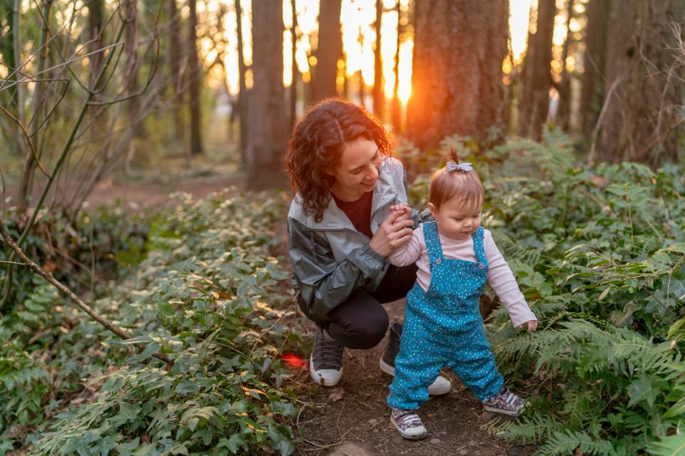 A mother hikes on a trail with her daughter.