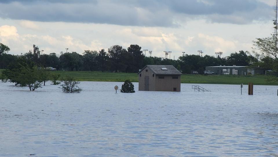 The restrooms are surrounded by water during flooding at McDonald Lake in John Stiff Memorial Park on Thursday.