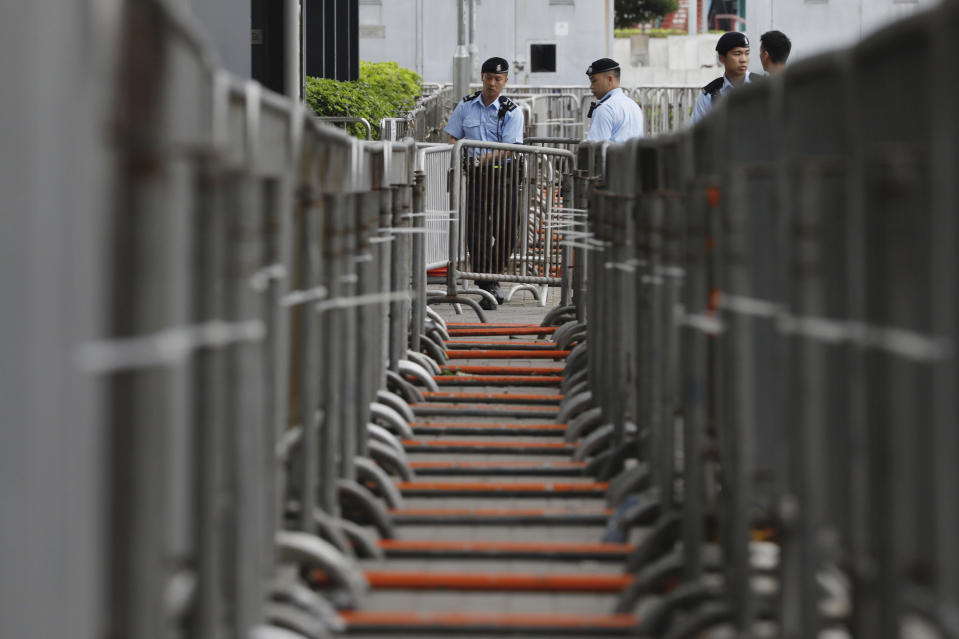 Police officers stand guard in front of barriers at the Legislative Council to prevent for stormed by protesters during upcoming meetings on the government's extradition law bill, in Hong Kong, Tuesday, June 11, 2019. Local media reports said police were mobilizing thousands of additional officers to keep order amid calls for protesters to begin gathering Tuesday night. Some businesses have also announced plans to close on Wednesday and scattered reports told of students planning to boycott classes. (AP Photo/Vincent Yu)