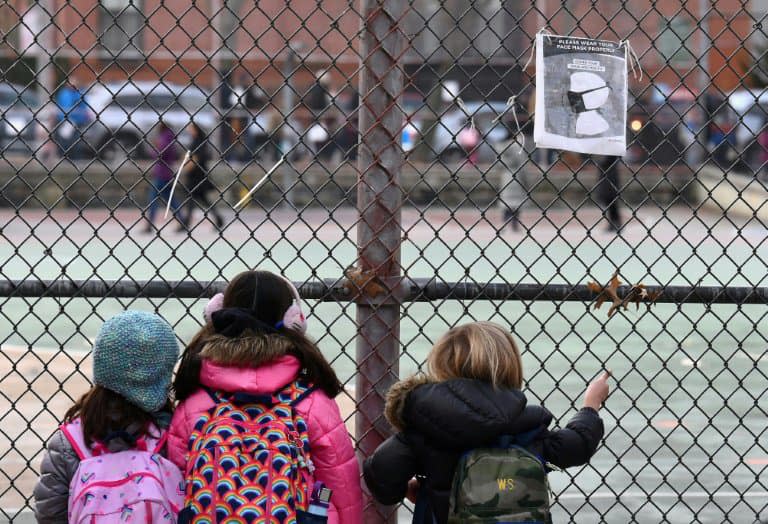 Des élèves attendent devant leur école lors du premier jour de réouverture, à New York (Etats-Unis), le 7 décembre 2020 - Angela Weiss © 2019 AFP