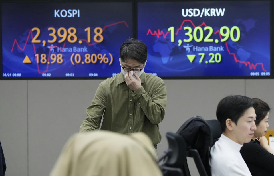 A currency trader passes by the screens showing the Korea Composite Stock Price Index (KOSPI), left, and the foreign exchange rate between U.S. dollar and South Korean won at the foreign exchange dealing room of the KEB Hana Bank headquarters in Seoul, South Korea, Tuesday, March 21, 2023. sian stock markets followed Wall Street higher on Tuesday ahead of a Federal Reserve decision on another possible interest rate hike amid worries about global banks. (AP Photo/Ahn Young-joon)