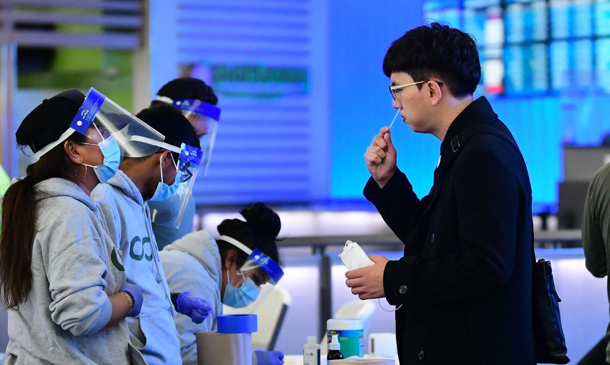 A man swabs his nose at a rapid Covid-19 testing site in the international terminal at Los Angeles International Airport on December 3, 2021. (Photo by Frederic J. BROWN/AFP)