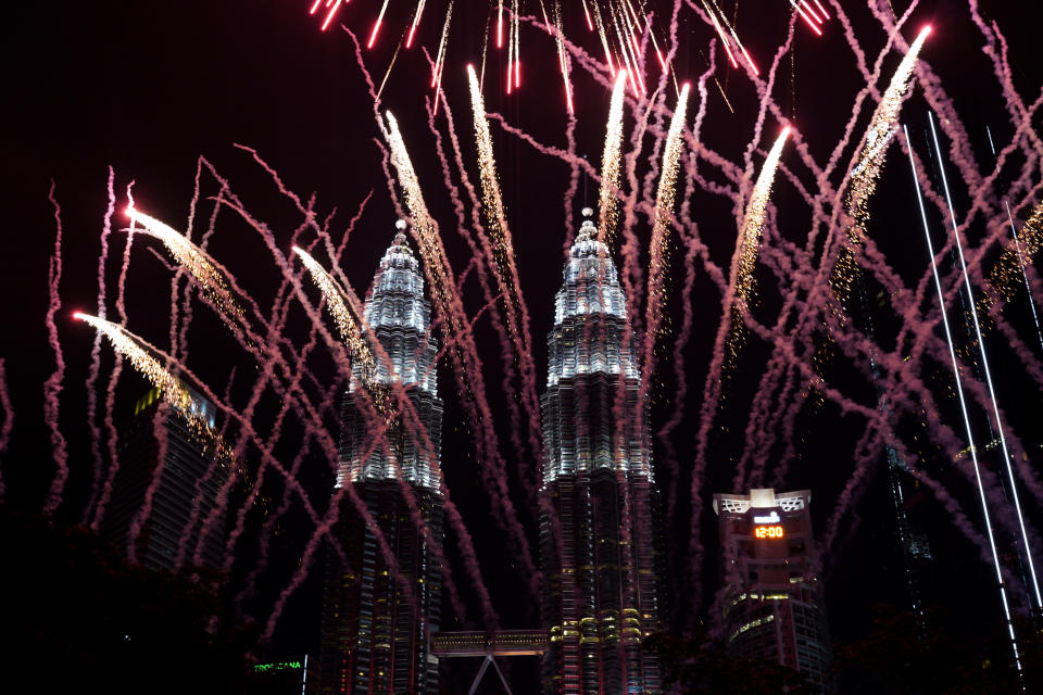 Fireworks explode in front of Malaysia's landmark building, the Petronas Twin Towers, during the New Year's celebration in Kuala Lumpur, Malaysia