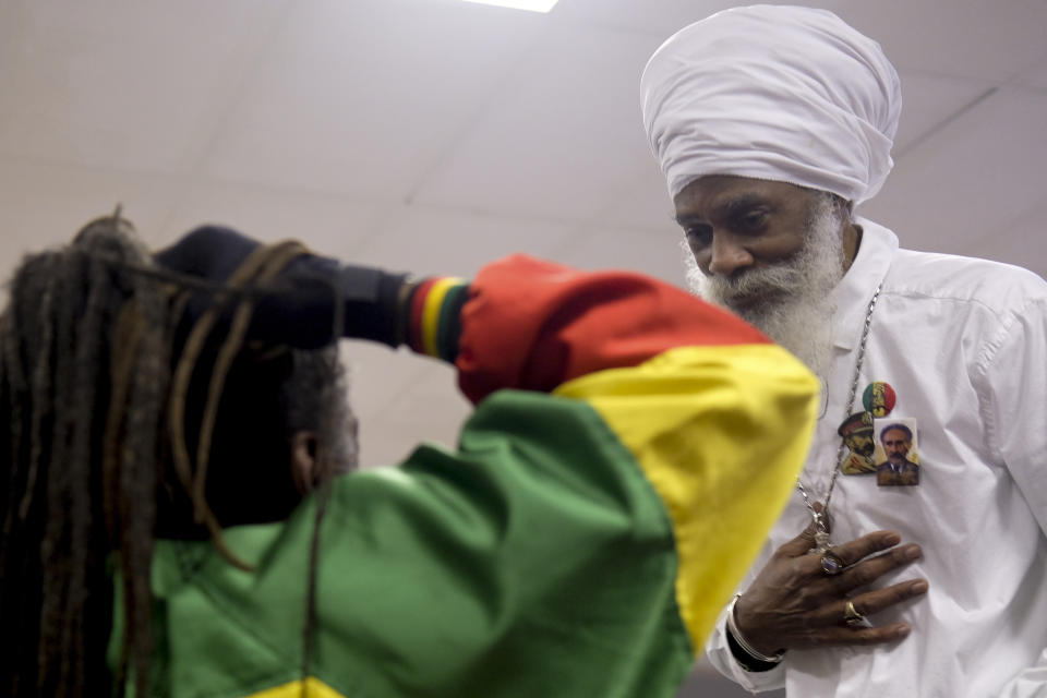 Lael Tafari, right, a respected elder in Ohio’s Rastafari community, greets Rastafari adherent Ras Zack Scott, left, on the sidelines of an event organized by the Columbus, Ohio-based Rastafari Coalition marking the 91st anniversary of the coronation of the late Ethiopian Emperor Haile Selassie I on Tuesday, Nov. 2, 2021 in Columbus, Ohio. (AP Photo/Luis Andres Henao)