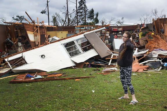 Haley Nelson stands in front of what is left of one of her fathers trailer homes after hurricane Michael passed through the area .