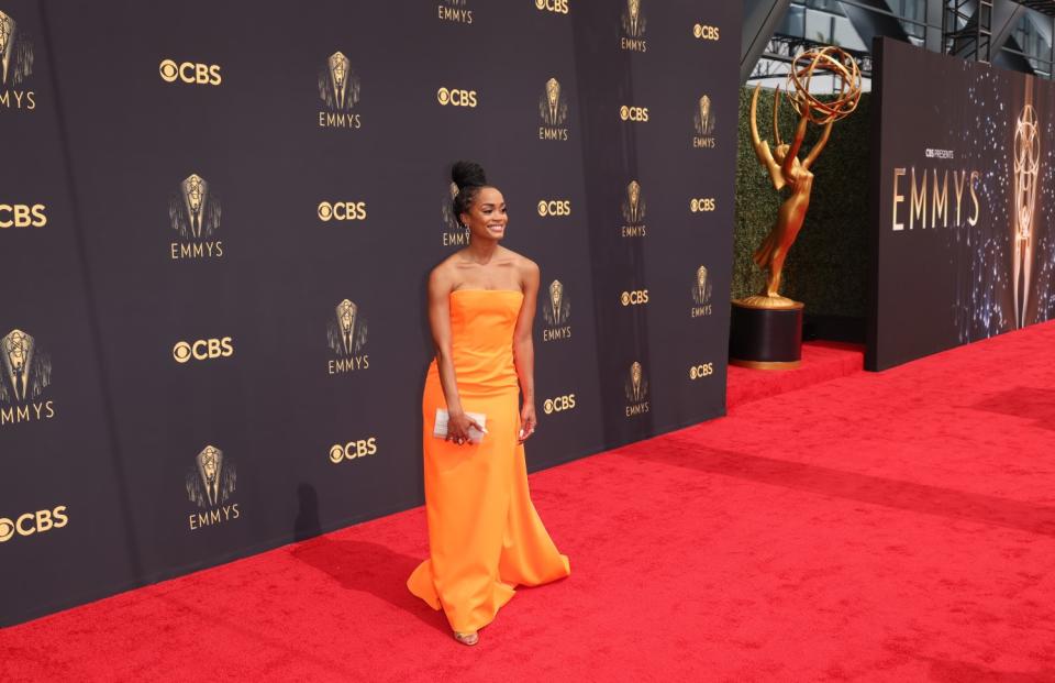 A woman holding a clutch in an orange gown