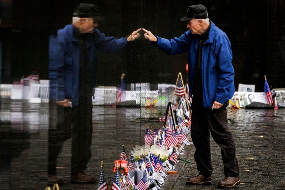 David Loesch, a 101st Airborne Veteran of the Vietnam War, searches for the names of soldiers from his unit on the Vietnam Veterans Memorial during Memorial Day.