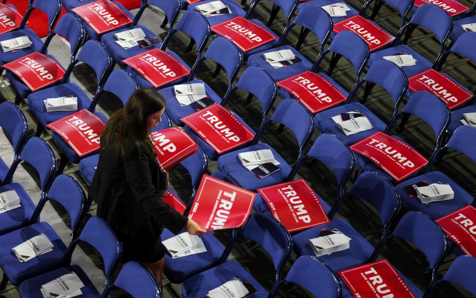 A person walks among seats with signs