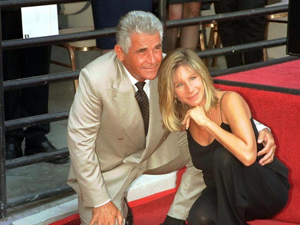 James Brolin, in a tan suit, poses with Barbra Streisand, in a black sleeveless dress, in front of his Hollywood Walk of Fame star in 1998.