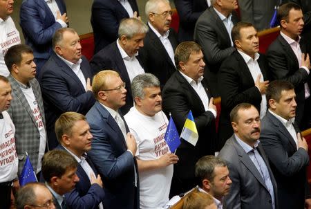 Ukrainian parliamentary deputies sing the national anthem after a ratification of a landmark association agreement with the European Union during a parliament session in Kiev September 16, 2014.REUTERS/Valentyn Ogirenko