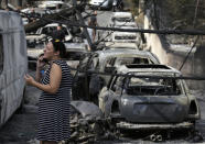 <p>A woman reacts as she stands amid the charred remains of burned-out cars in Mati east of Athens, Tuesday, July 24, 2018. (Photo: Thanassis Stavrakis/AP) </p>