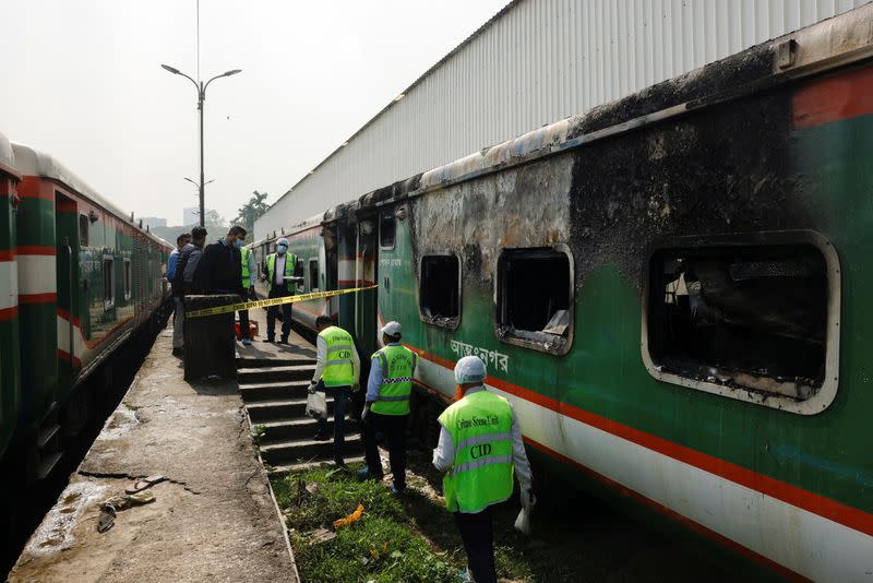 Crime Scene Unit members inspect the passenger train that was set on fire during a countrywide strike called by the Bangladesh Nationalist Party, in Dhaka