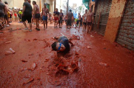 A reveller plays with tomato pulp during the annual "Tomatina" festival in Bunol, near Valencia, Spain, August 29, 2018. REUTERS/Heino Kalis