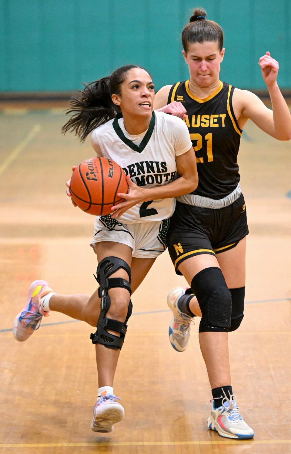 Dennis-Yarmouth's Jaylene Pires drives to the hoop past Gabby Foster of Nauset in Thursday's game in South Yarmouth.