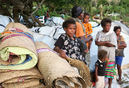 Residents stand with their possessions as they prepare to board a boat at Lolowai Port as they evacuate due to the Manaro Voui volcano continuing to emanate smoke and ash on Vanuatu's northern island of Ambae in the South Pacific, October 1, 2017. REUTERS/Ben Bohane