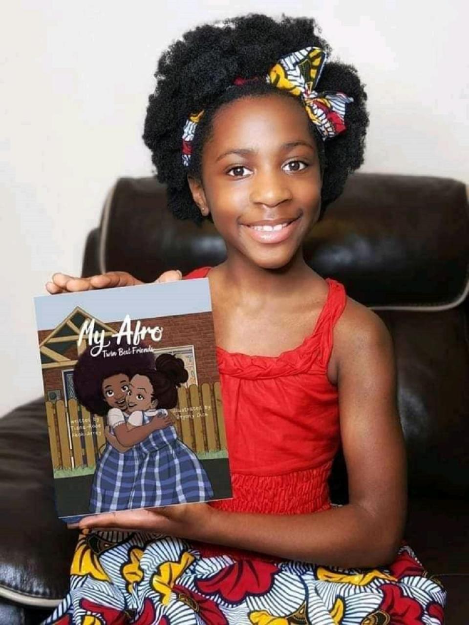 Little girl holding a book and looking at the camera