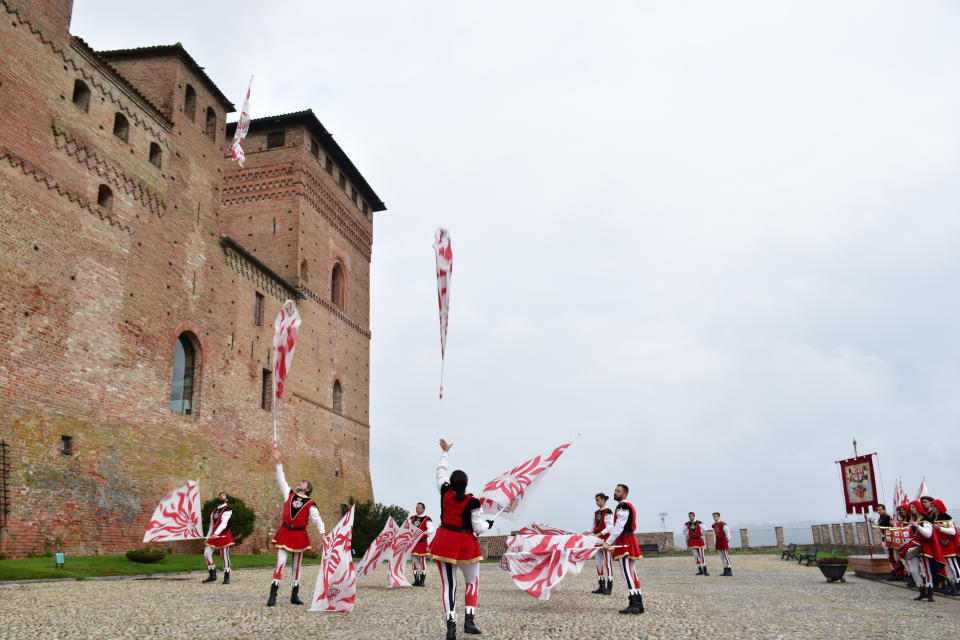In this photo taken on Sunday, Nov. 10, 2019, flag throwers perform outside the castle in Grizane Cavour, where every year officials hold the famed Alba truffle auction, which has fetched more than 4.5 million euros for charity in recent years. This year's top bid was for a truffle weighing 1,005 grams which sold to a buyer in Hong Kong for 130,000 euros. (AP Photo/Martino Masotto)