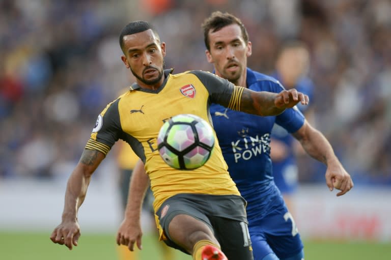 Arsenal's midfielder Theo Walcott (L) tries to hold off Leicester City's defender Christian Fuchs on August 20, 2016