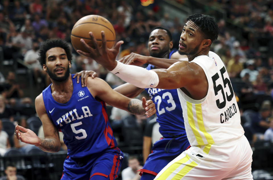 Utah Jazz' Bruno Caboclo (55) reaches for a rebound ahead of Philadelphia 76's Julian Champagnie (5) and Charles Bassey (23) during a summer league basketball game in Salt Lake City on Wednesday, July 6, 2022. (Scott G. Winterton/The Deseret News via AP)