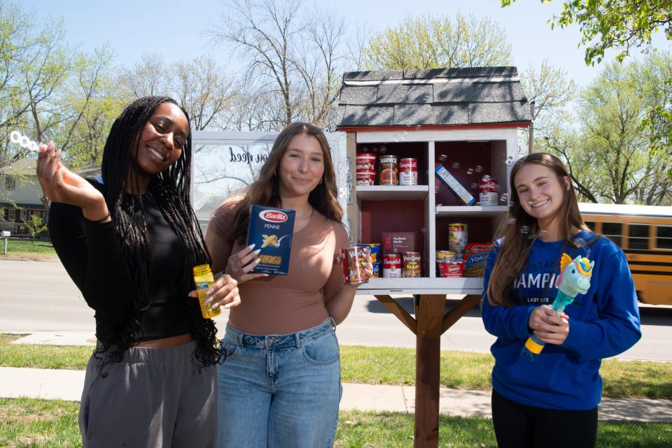 Washburn Rural students, from left, Naledi Mackenzie, Sienna Hamilton and Megan Weis are part of the Bee the Blessing group, which replenishes more than 40 Blessing Boxes across Topeka.