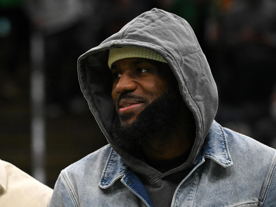 LeBron James watches Thursday's Lakers-Celtics game in street clothes. (Brian Fluharty/Getty Images)
