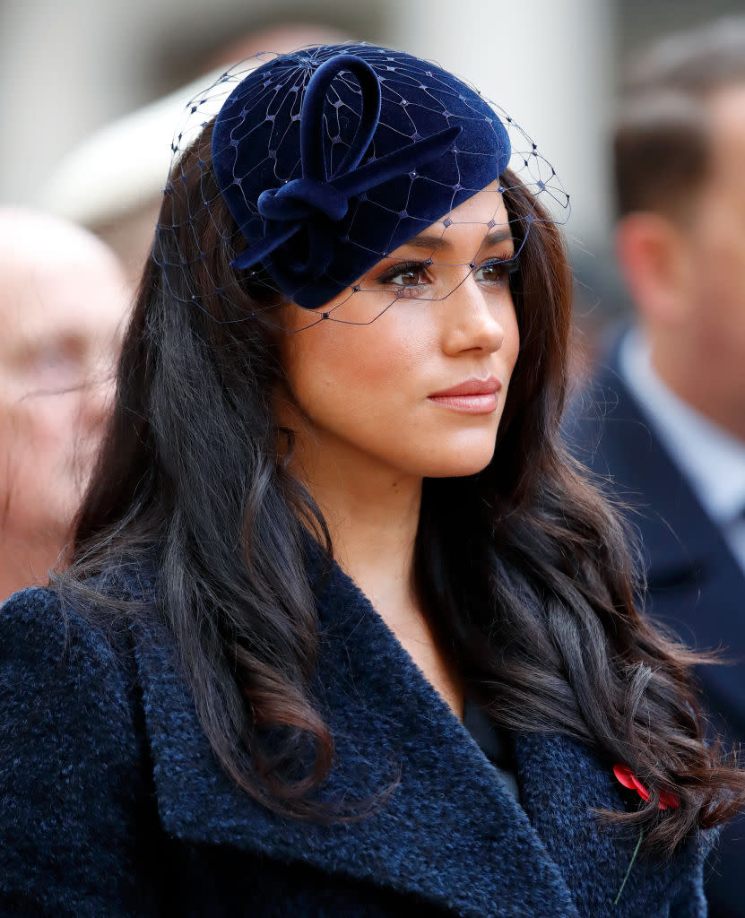 Meghan Markle looking sombre in a navy blue suit. 