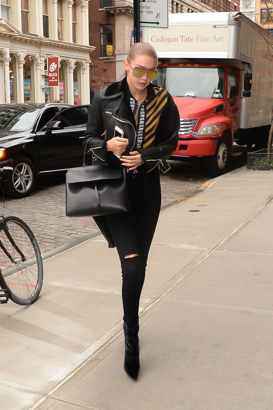 <p>In a leather shearling jacket, striped zip-up top, black skinny jeans, velvet ankle boots, Mansur Gavriel bag and reflective aviators while out in NYC.</p>