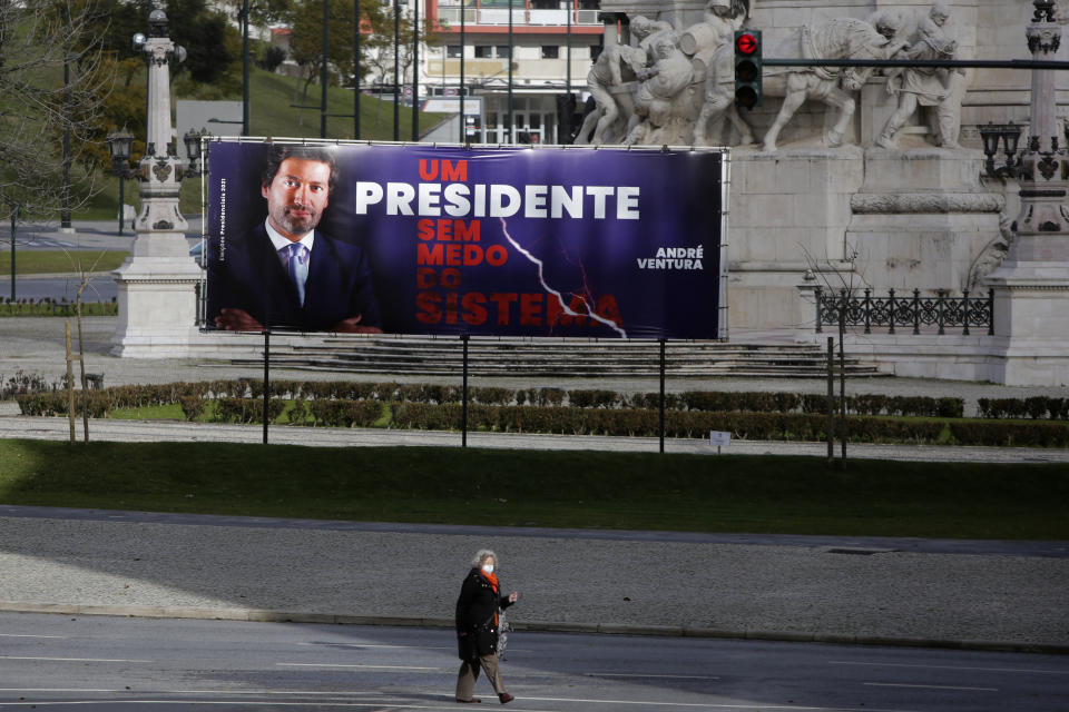 A woman walks in front of an election campaign billboard for presidential candidate Andre Ventura, with the slogan "A president without fear of the system", in Lisbon, Friday, Jan. 22, 2021. Portugal holds a presidential election upcoming Sunday. (AP Photo/Armando Franca)
