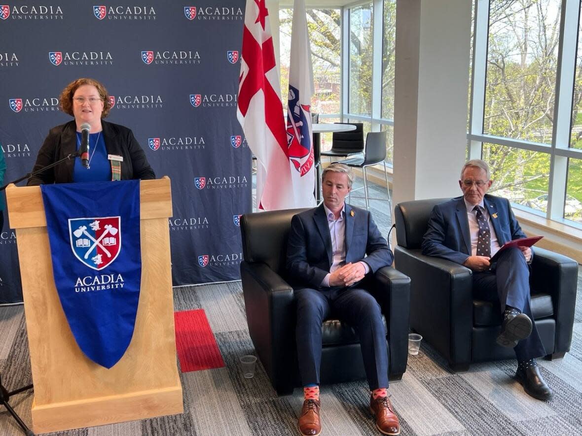 Cape Breton University dean of nursing Kimberley Lamarche speaks at a news conference that included Premier Tim Houston and Acadia University president Peter Ricketts, seated. (Mark Crosby/CBC - image credit)