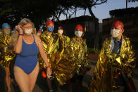 Competitors prepare for a harbor race at the Victoria Harbor in Hong Kong, Sunday, Dec. 12, 2021. Hundreds of people took part in traditional swim across iconic Victoria Harbor after two years of suspension. (AP Photo/Kin Cheung)