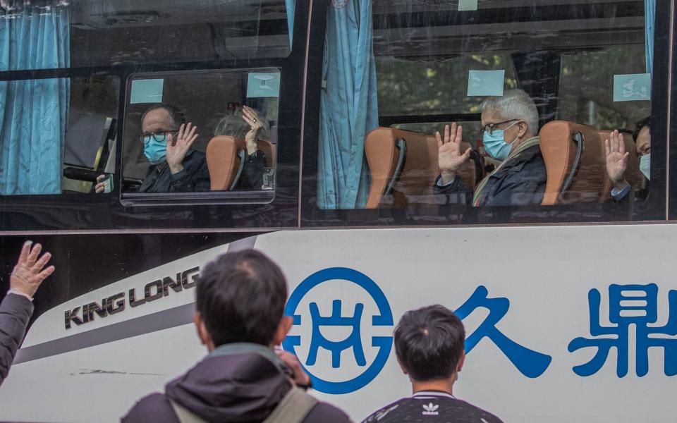Members of the World Health Organization (WHO) team sit in a bus as they leave the Jade Boutique hotel in Wuhan after the mandatory 14-day quarantine, - Shutterstock